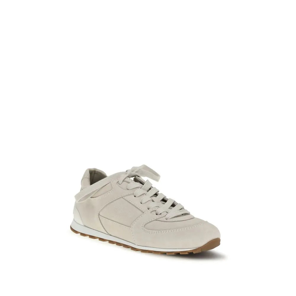 Light beige suede low-top sneakers with white laces, stitched details, and a brown rubber sole.