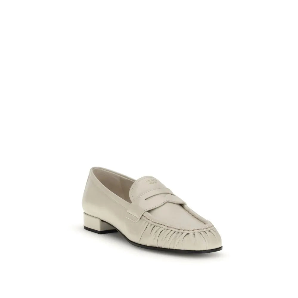 Light beige calf leather Prada loafers with a ruched toe, logo strap, and low block heel.