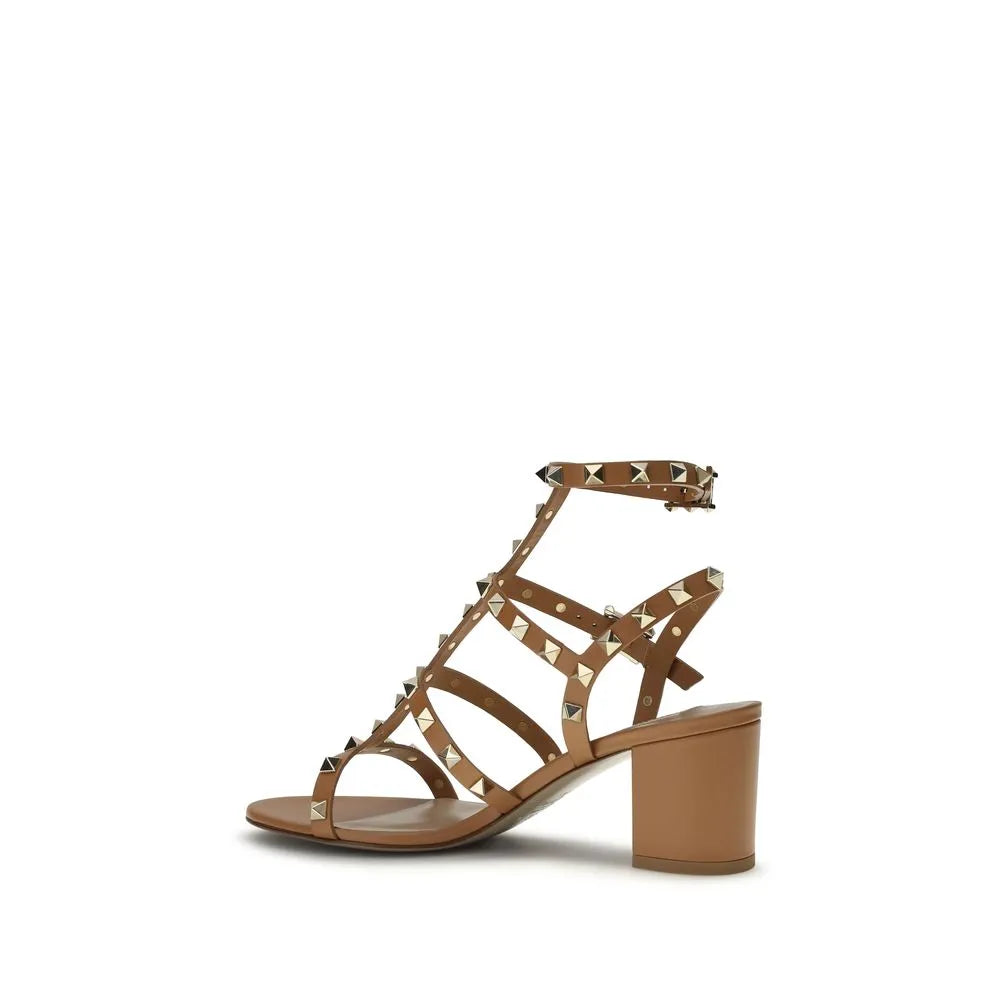 Beige calf leather Rockstud sandals with gold studs, strappy design, adjustable ankle strap, and block heel.