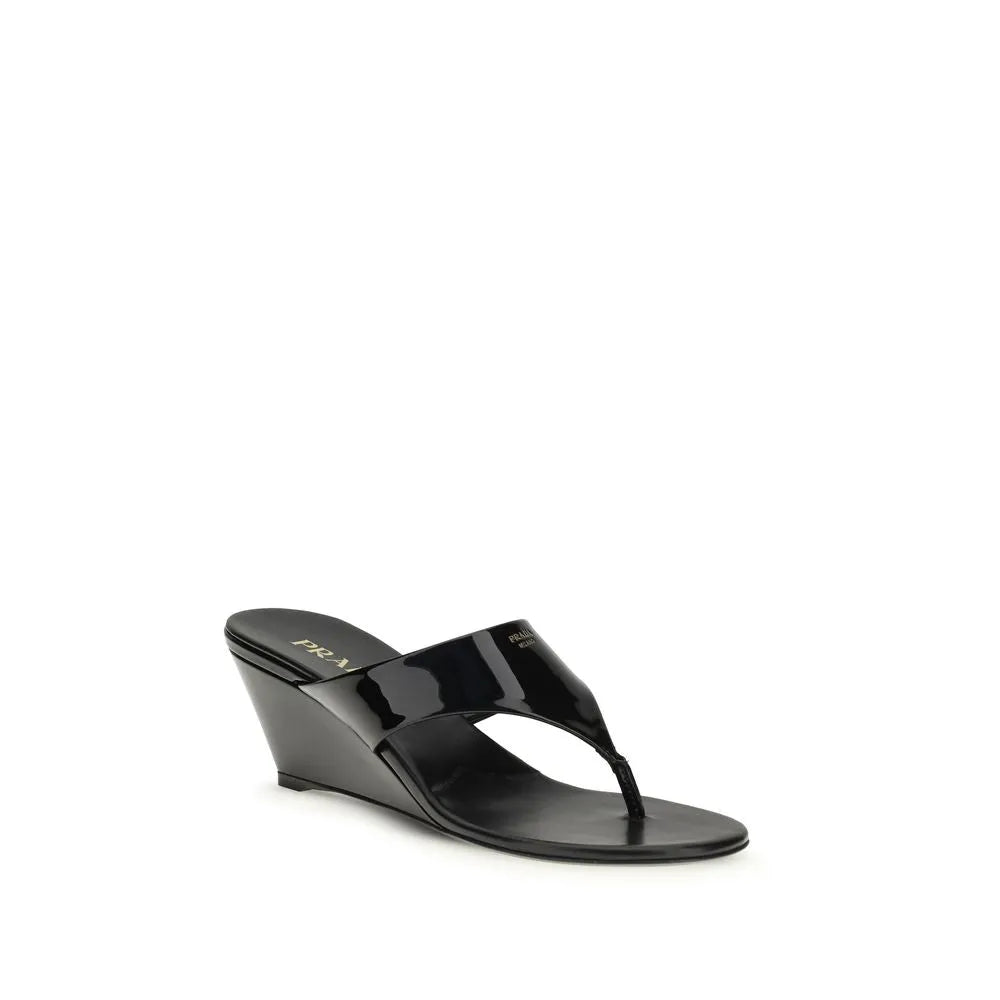 Black patent leather Prada thong wedge sandals with visible logo and round toe.