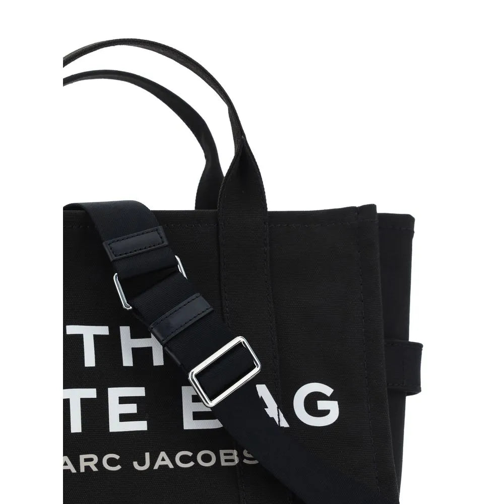 Black cotton Marc Jacobs Medium Tote Bag featuring white 'THE TOTE BAG' logo and adjustable shoulder strap with silver hardware.