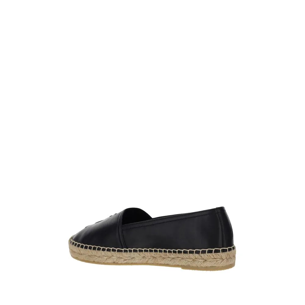 Black lambskin Saint Laurent slip-on espadrille with flat rope sole, elongated toe, and subtle monogram.