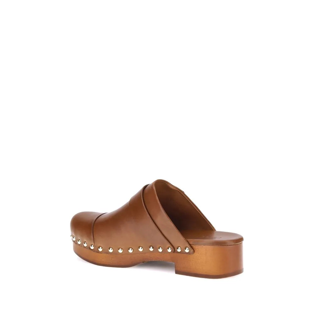 Chloé Jeannette brown calf leather clogs with round toe, wooden platform, low wide heel, and golden studs.