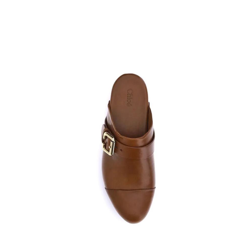 Brown Chloé Jeannette calf leather mule clog with a golden Paddington buckle, round toe, and wood platform.