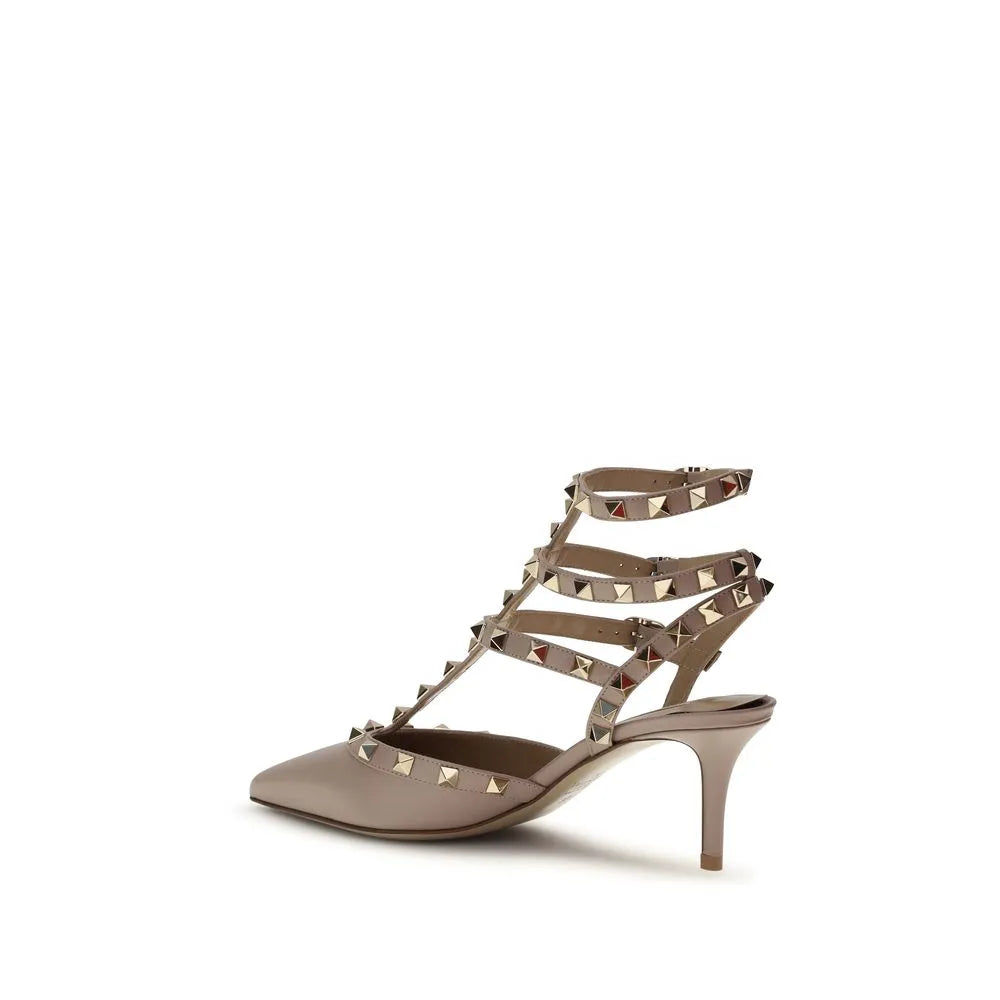 Nude calf leather Valentino Garavani Rockstud pump with pointed toe, studded ankle straps, and mid stiletto heel.