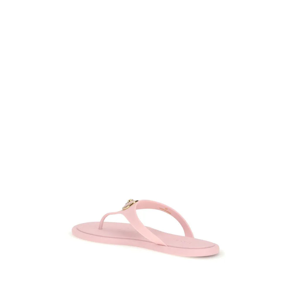 Light pink rubber thong sandal by Versace featuring a gold Medusa appliqué on the instep.