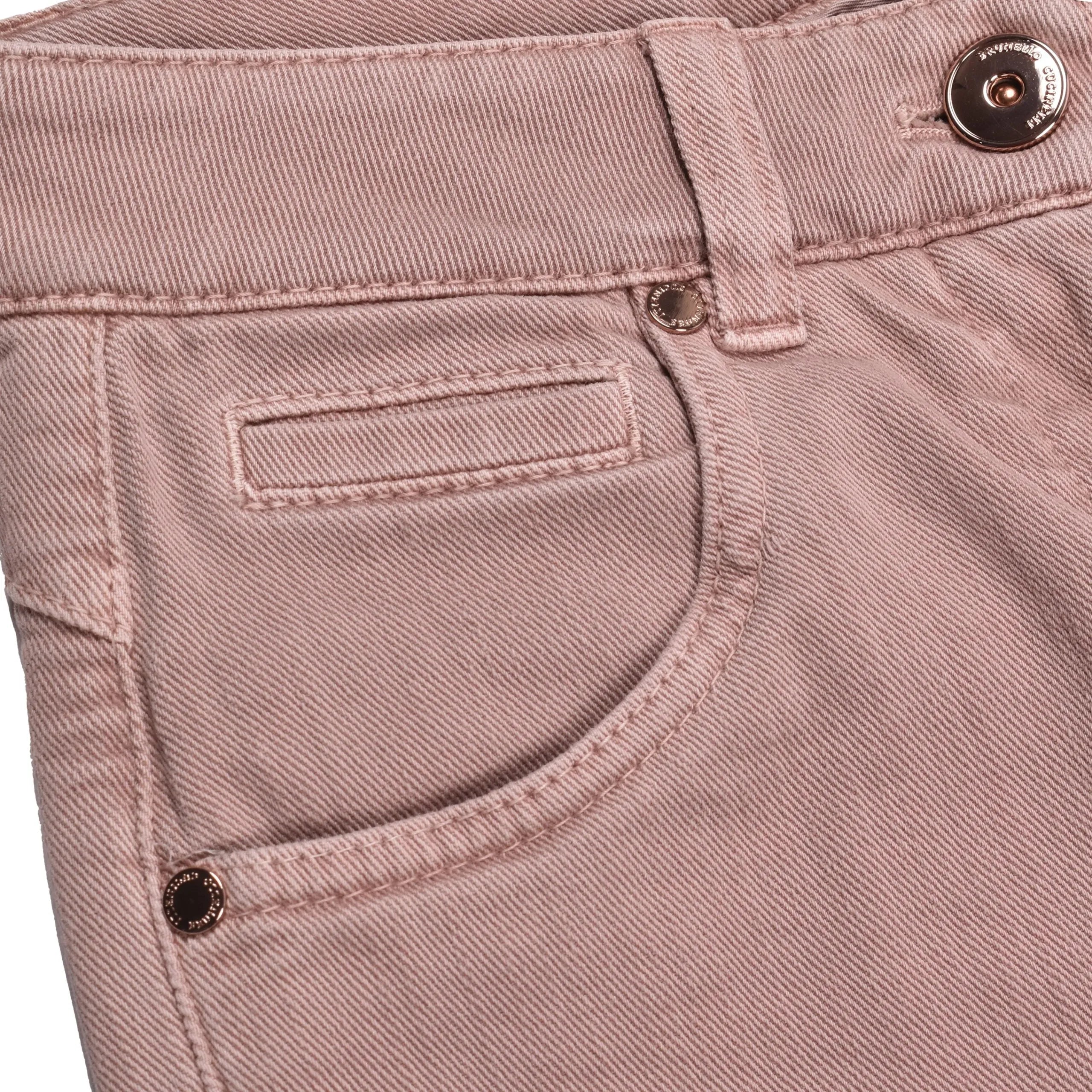 Close-up of Pink Sand cotton jeans, featuring a curved front pocket, flap coin pocket, and copper button.