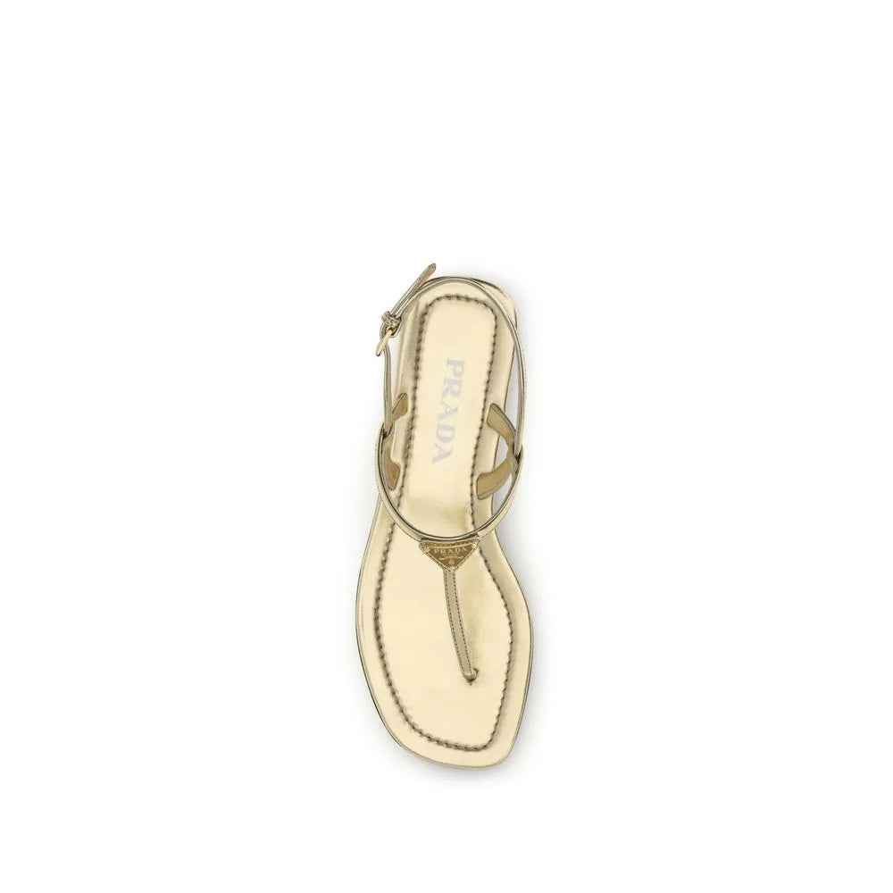 Gold patent calf leather Prada flat thong sandal with iconic triangle logo, adjustable ankle strap, and squared toe.