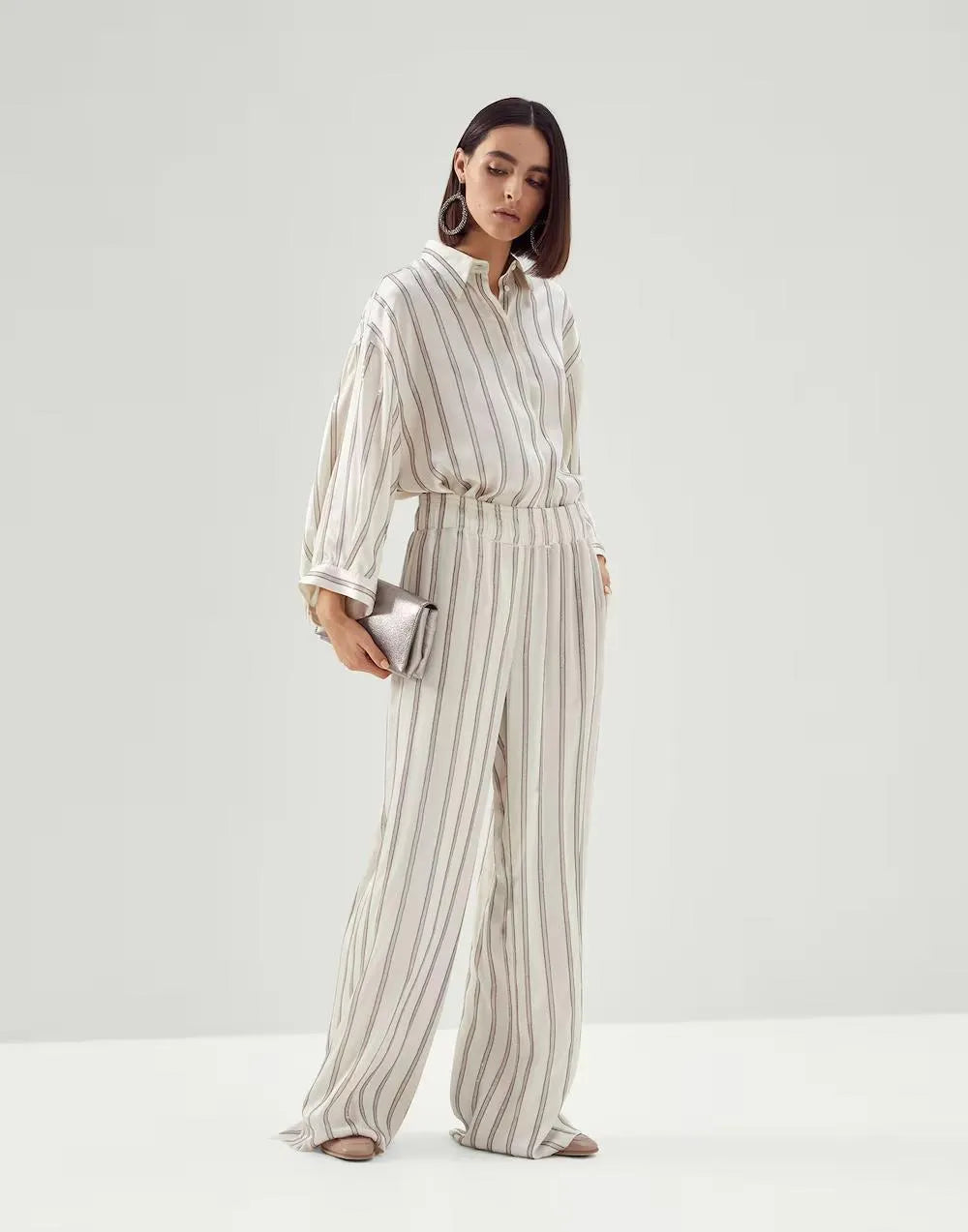 Brunello Cucinelli warm white striped wide-leg women's pants and matching long-sleeve shirt.