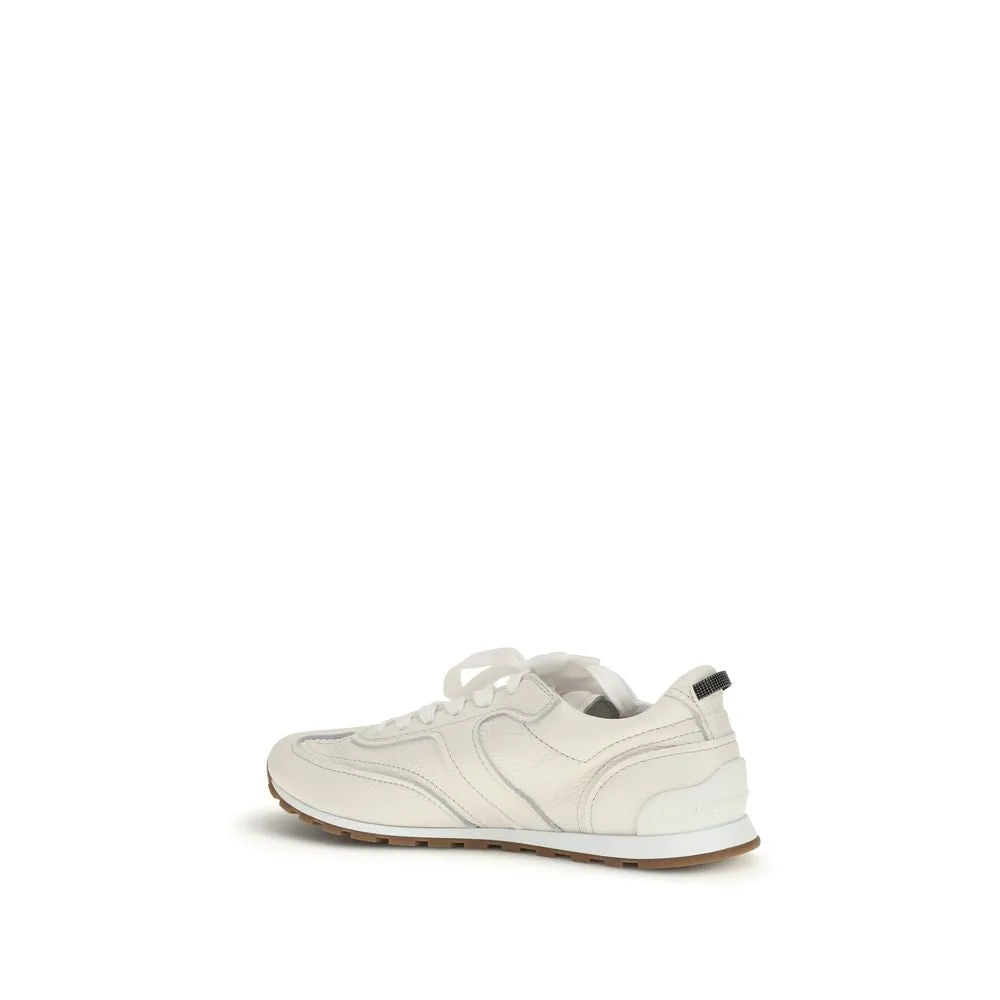 White calf leather Brunello Cucinelli low-top sneakers with white laces, heel pull tab, and brown rubber sole.