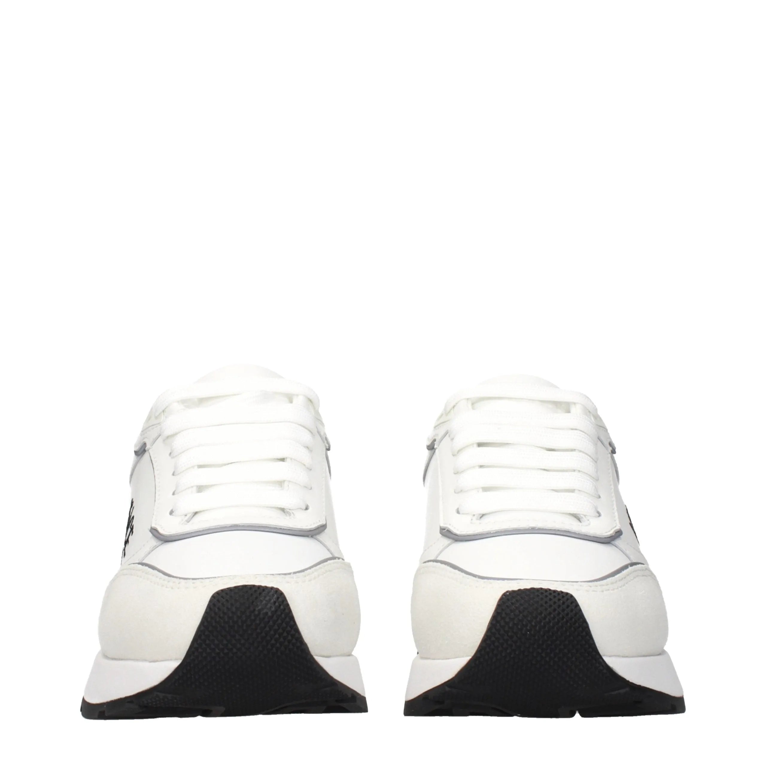 Pair of white leather low top Versace sneakers with black textured soles and side logo.