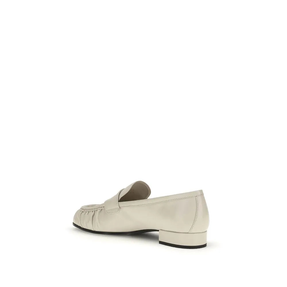 Light beige calf leather slip-on loafers with pleated vamp and low black block heel.