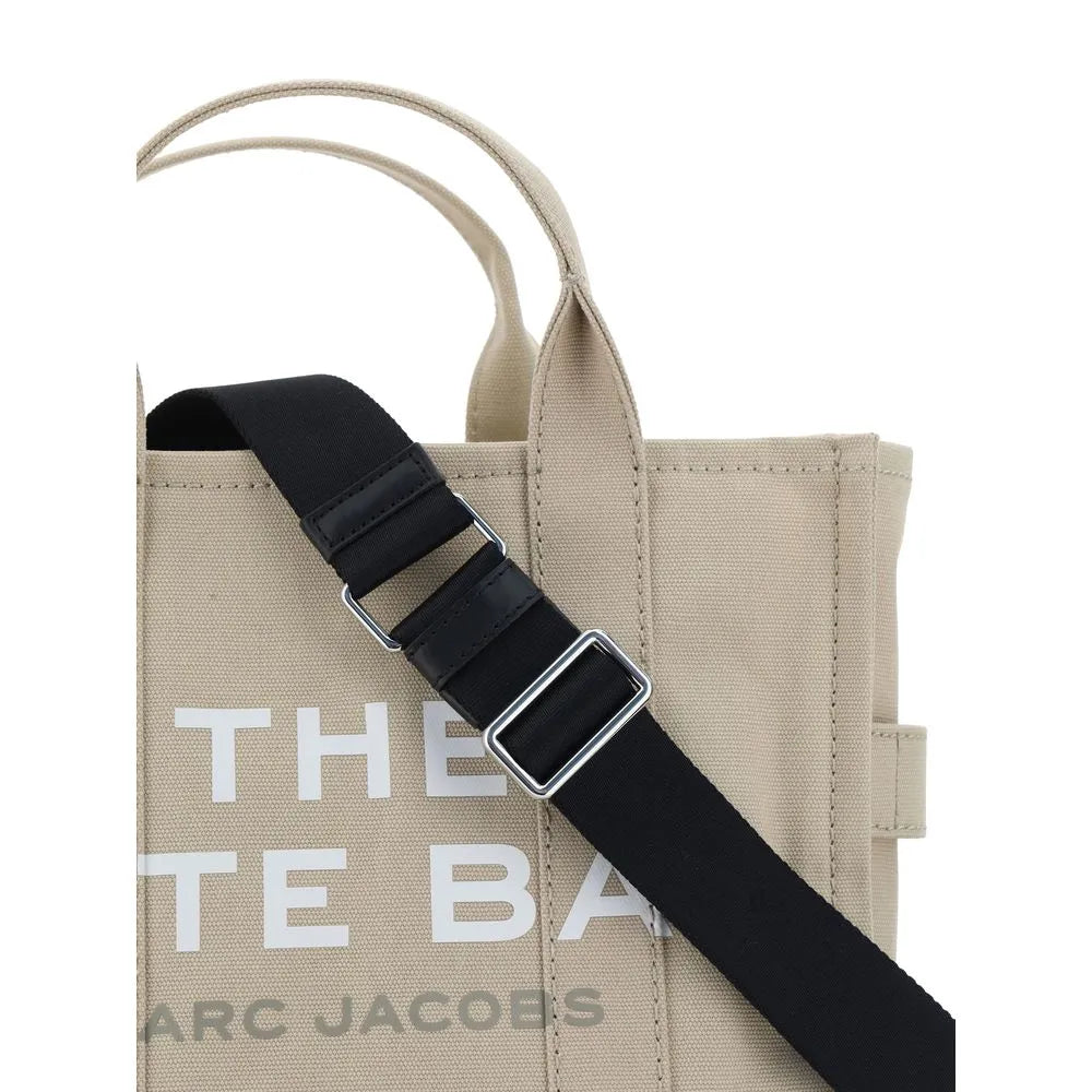 Marc Jacobs beige cotton Medium Tote Bag with black adjustable strap, top handles, and white 'THE TOTE BAG' print.