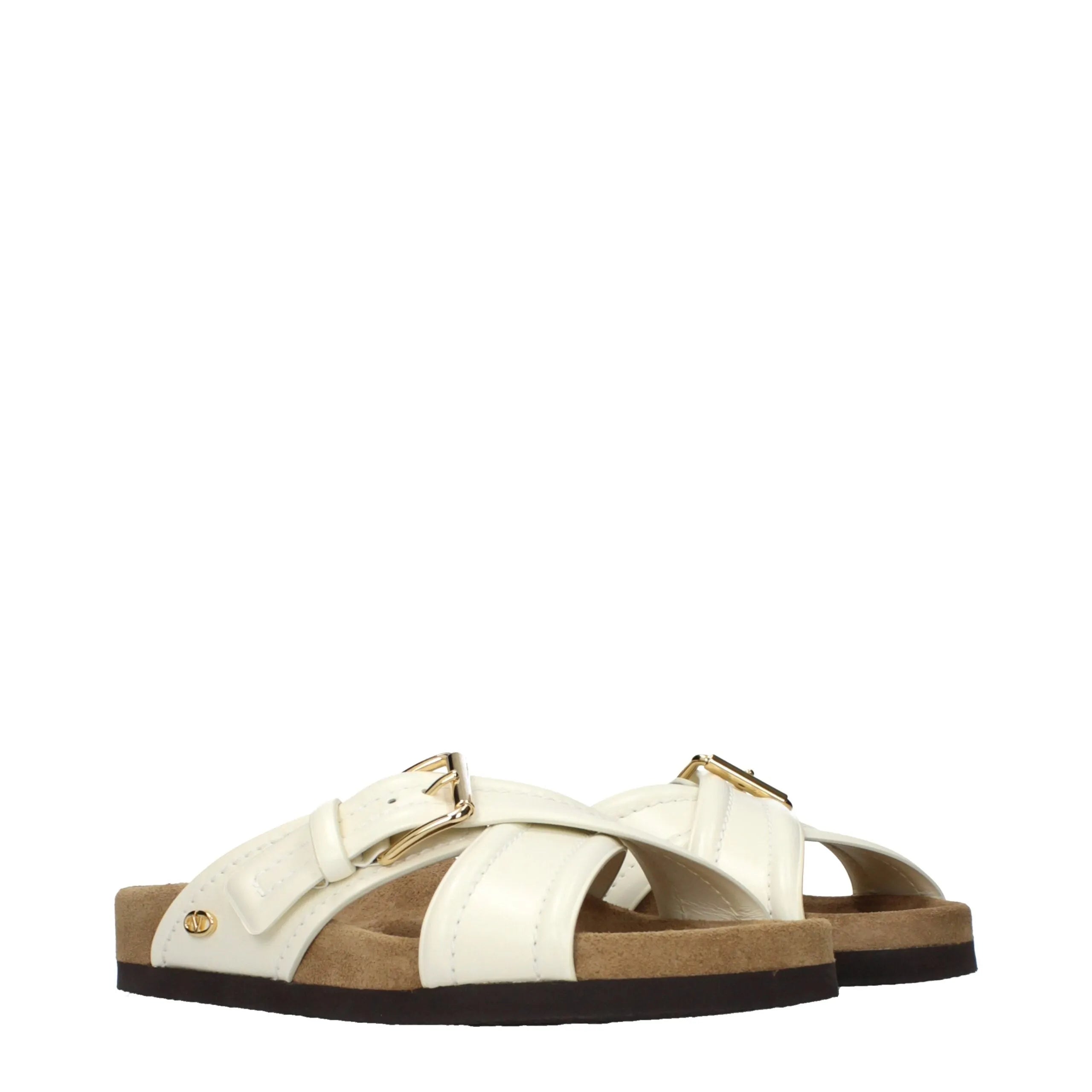 Beige leather Valentino Garavani slippers with criss-cross straps, gold buckles, side V logo, and a thick cork-style sole.