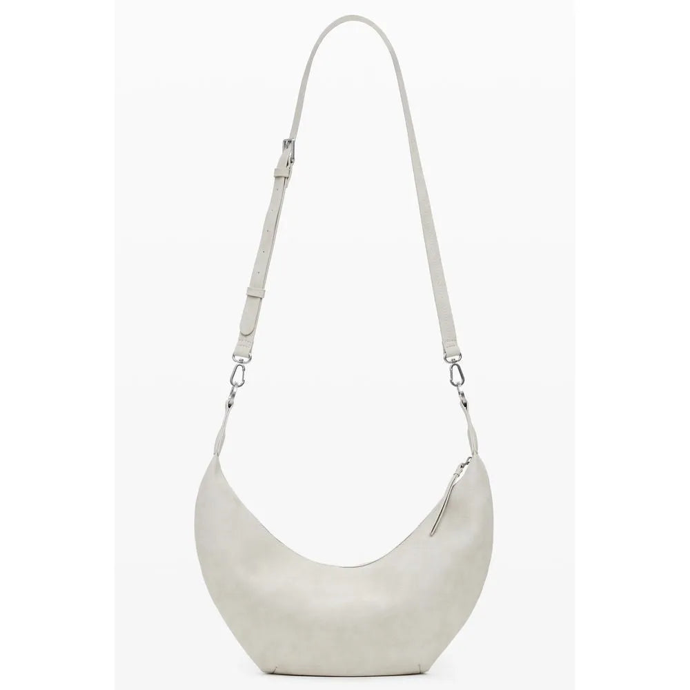 Beige polyurethane women's crescent shoulder bag with a smooth finish, adjustable strap, and zip closure.