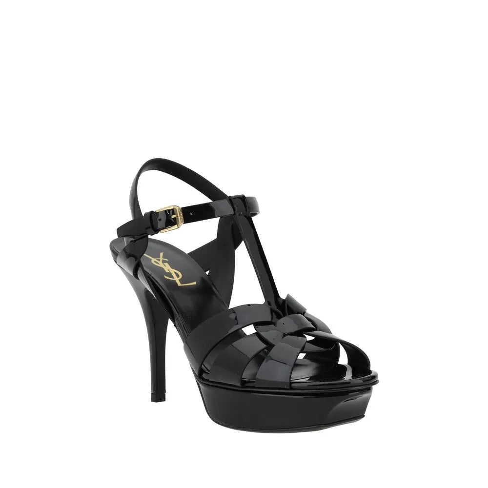 Black patent calf leather Saint Laurent Tribute platform stiletto sandals with caged upper and gold buckle.