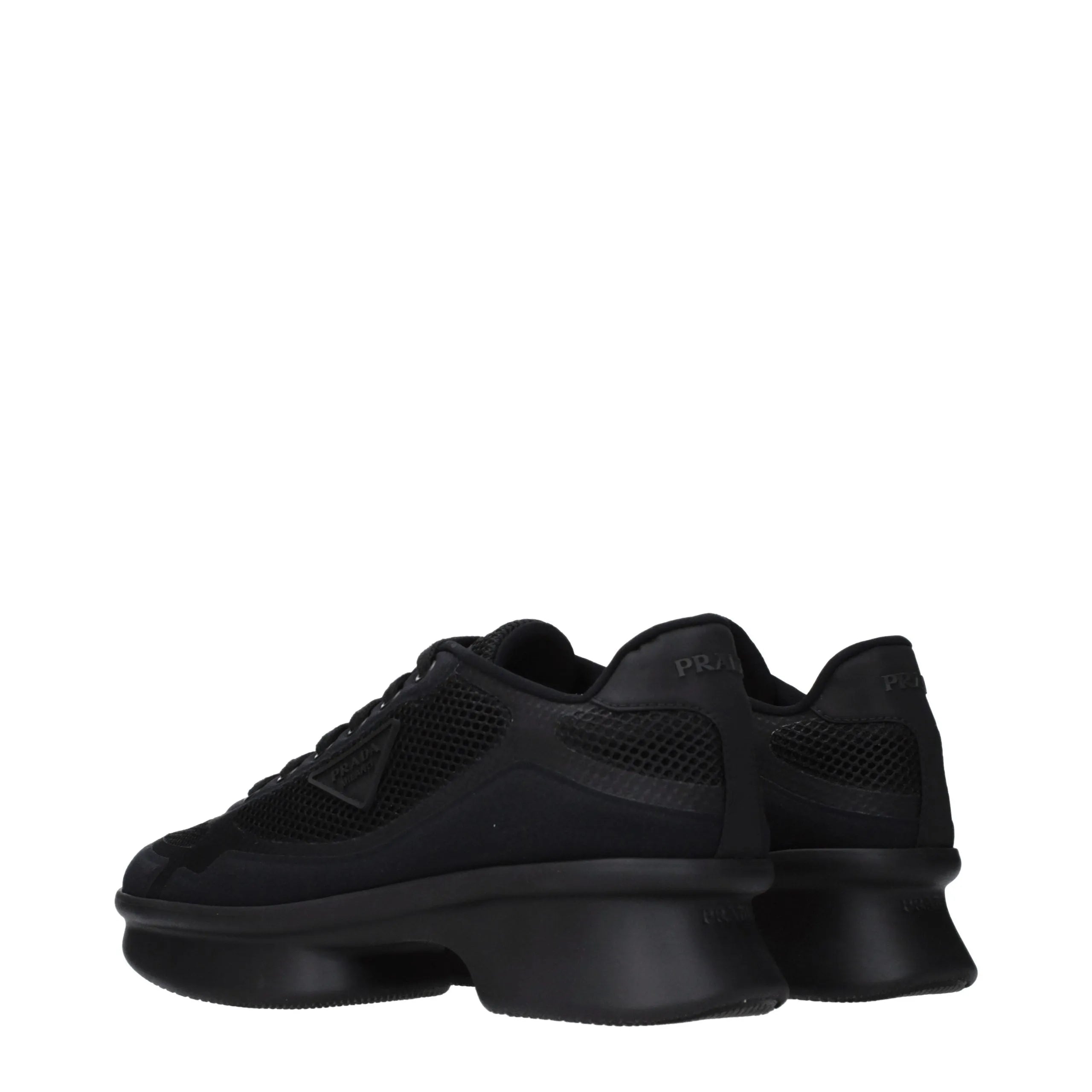 Black Prada fabric low-top sneakers with mesh details and chunky sculpted soles, showing back logo.