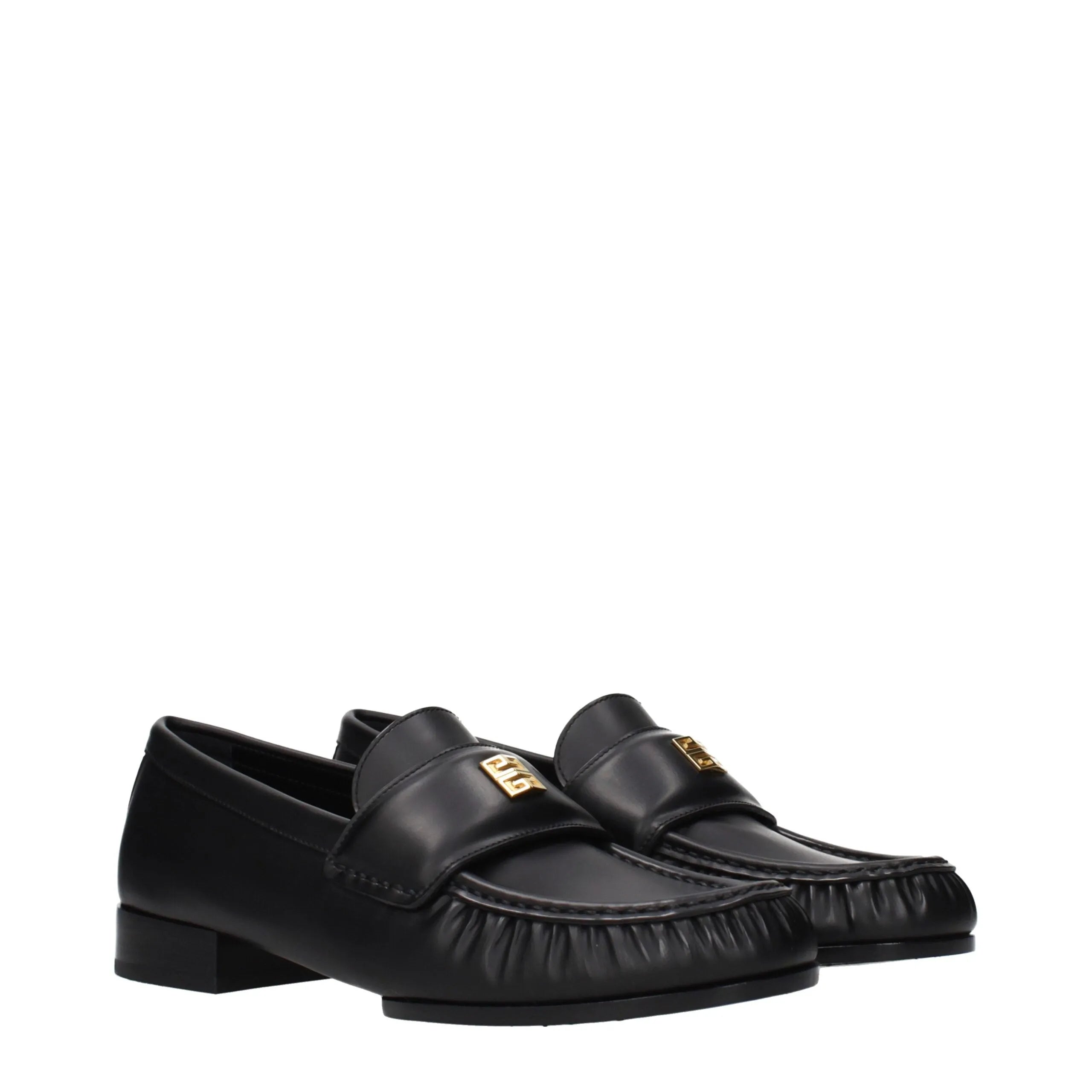 Givenchy black leather slip-on loafers featuring a gold front logo and pleated toe detail.