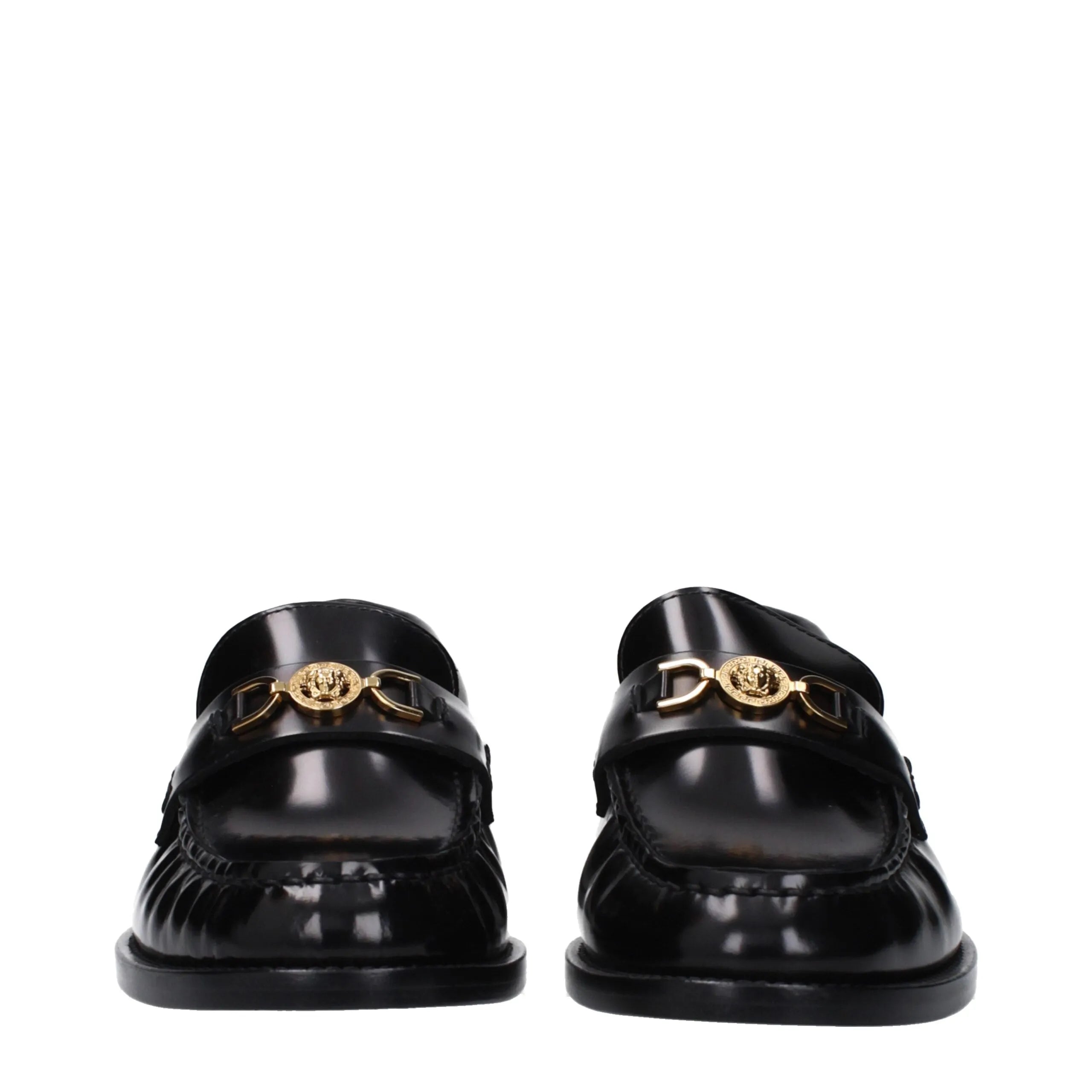 Shiny black leather slip-on loafers by Versace, featuring a gold Medusa logo front detail and round toe.