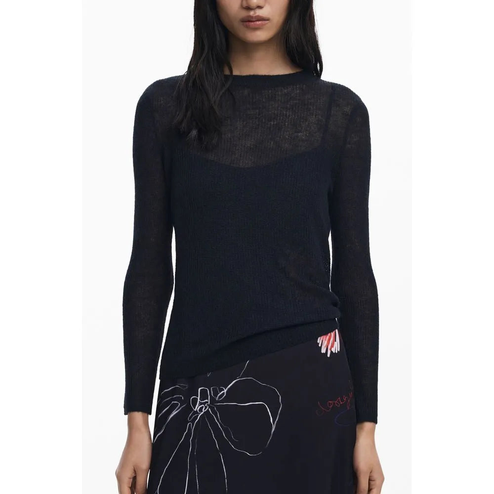 Woman wearing a sheer black long-sleeved crew neck top and a black skirt with white line art.