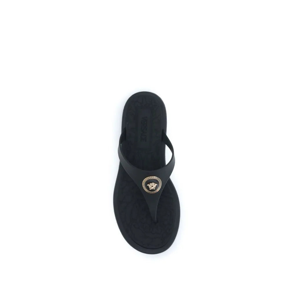 Black rubber Versace thong sandal with gold Medusa appliqué and embossed logo.