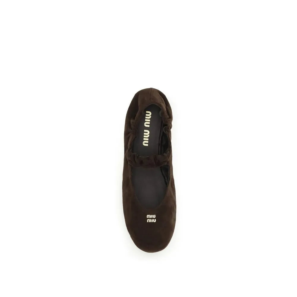Miu Miu dark brown suede ballet flat with round toe, ruffled instep strap, and gold logo.