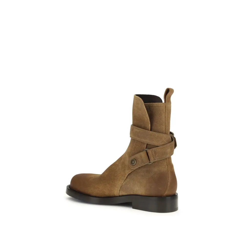 Brown suede calf leather ankle boot with rounded toe, adjustable straps, and metal buckle.