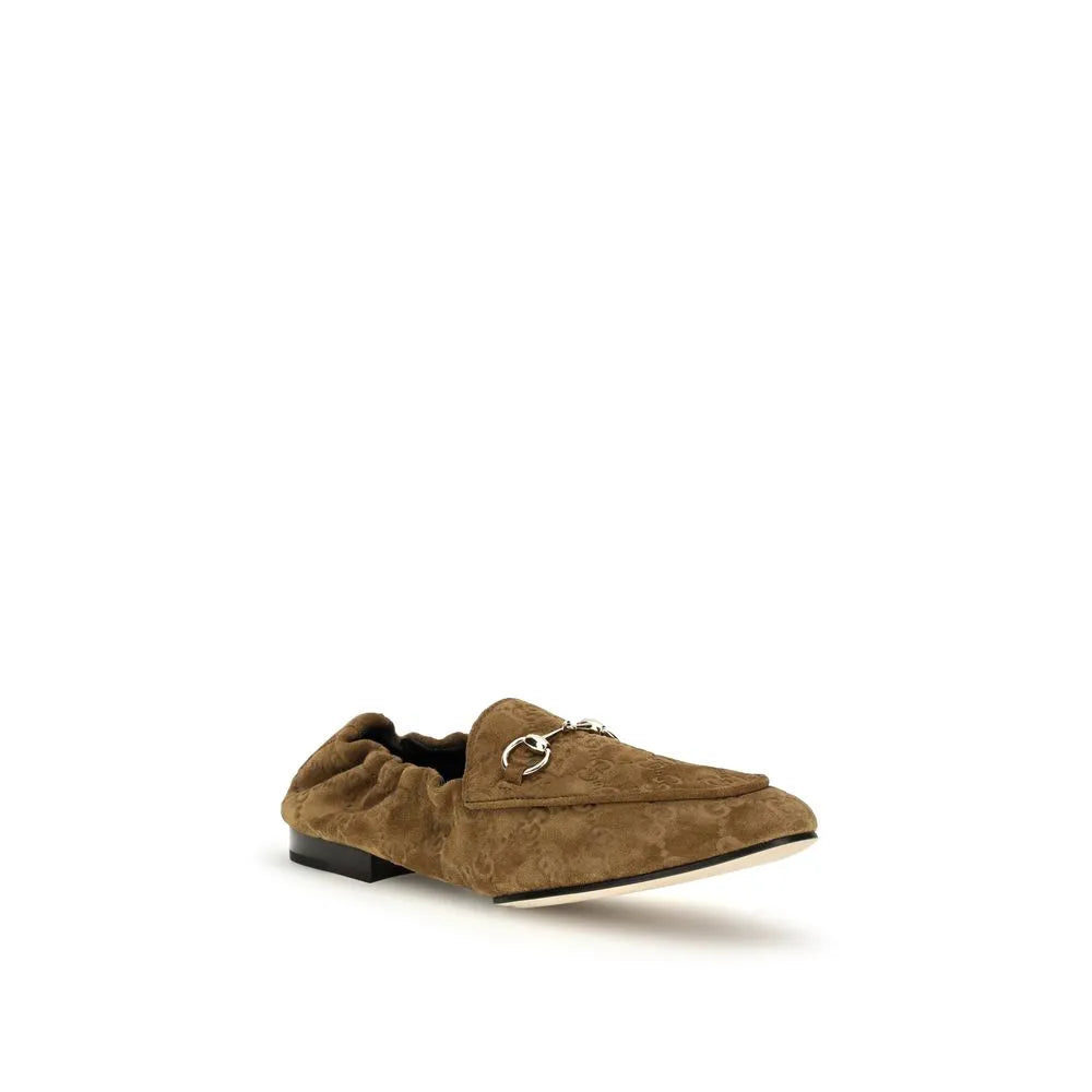 Brown suede Gucci loafer with embossed GG motif, silver horsebit, and ruched heel.