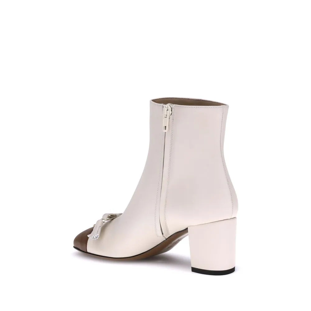 Cream goatskin ankle boot featuring a contrasting brown toe, antiqued brass VLogo, leather tassel bow, and side zip.